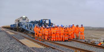 Tracklaying concluded on EWR: the team stands in front of the New Track Construction Train after its final duty on the new railway. East West Rail