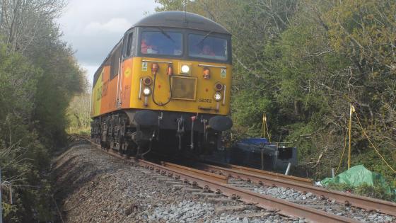 Back on the grid - Colas Rail No 56302 passes the site of the proposed Okehampton Parkway station to collect a track relaying train ANDY RODEN